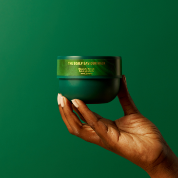 The Steam Bar's The Scalp Saviour Mask held in black model's hand against green background